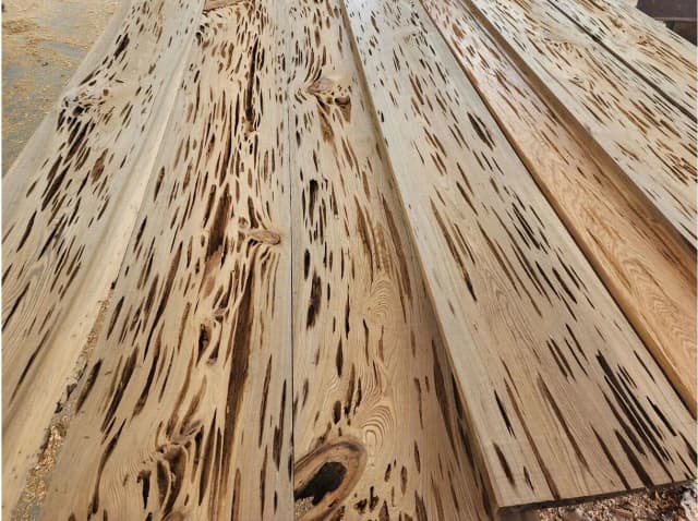 Stacked Cypress (Cupressus) wood beams, known for their natural durability and strength.